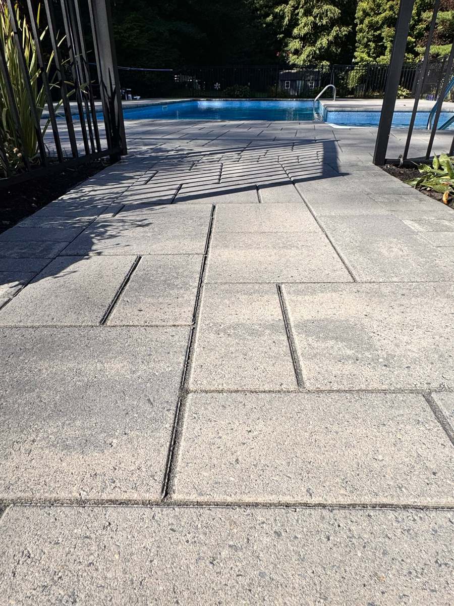 Sealed paver path leading to a backyard pool in Rhode Island